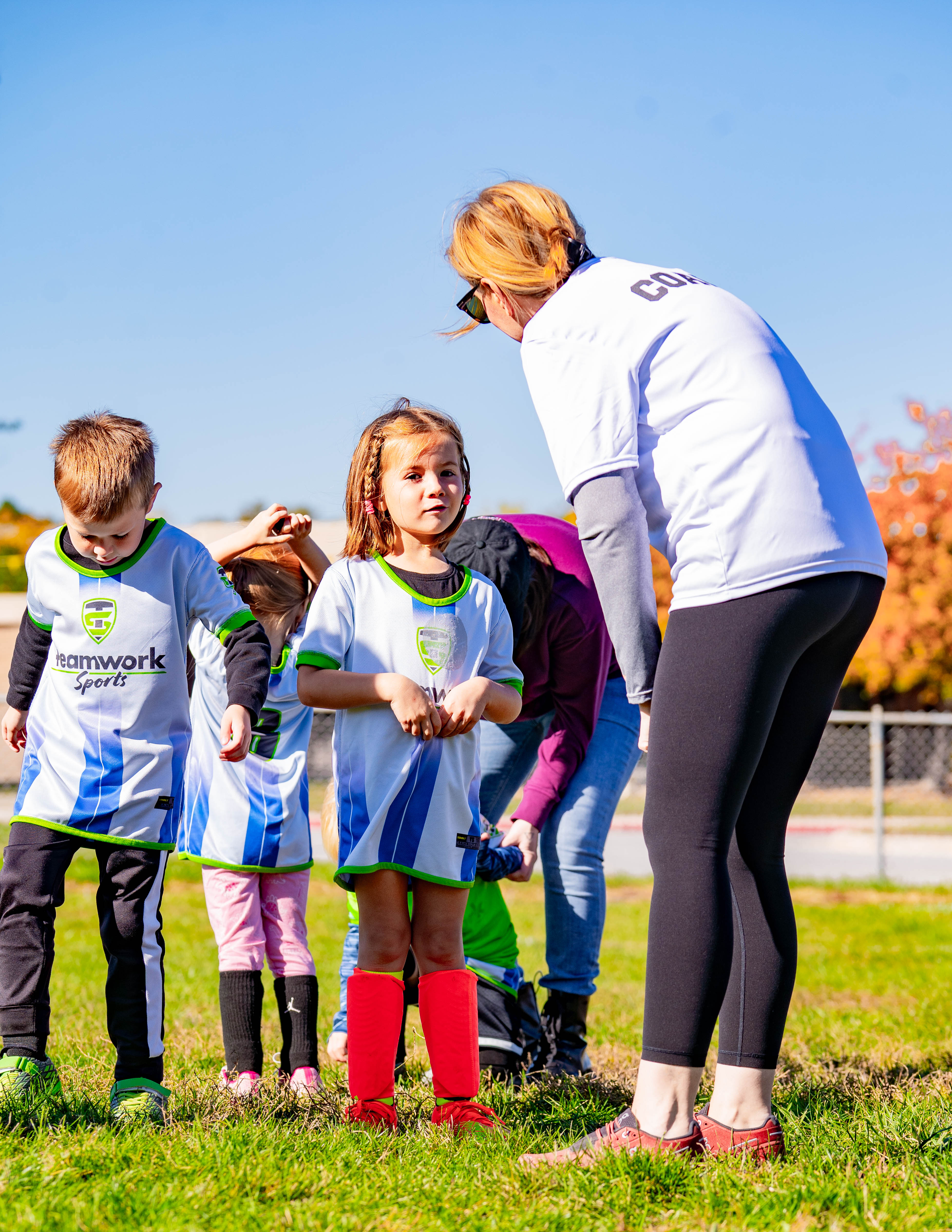 A Teamwork Sports coach helping young soccer players get ready
