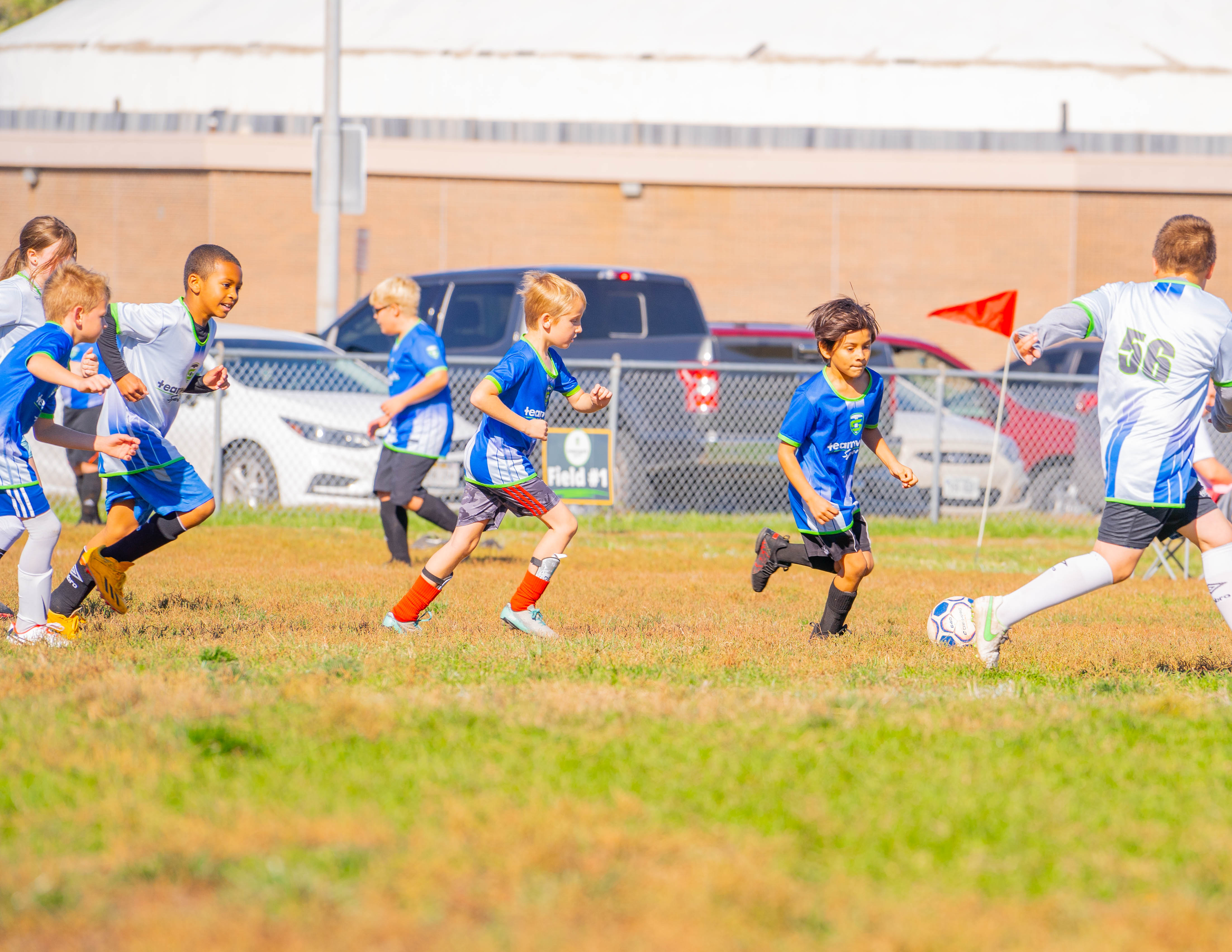 Kids running downfield during a fall soccer match