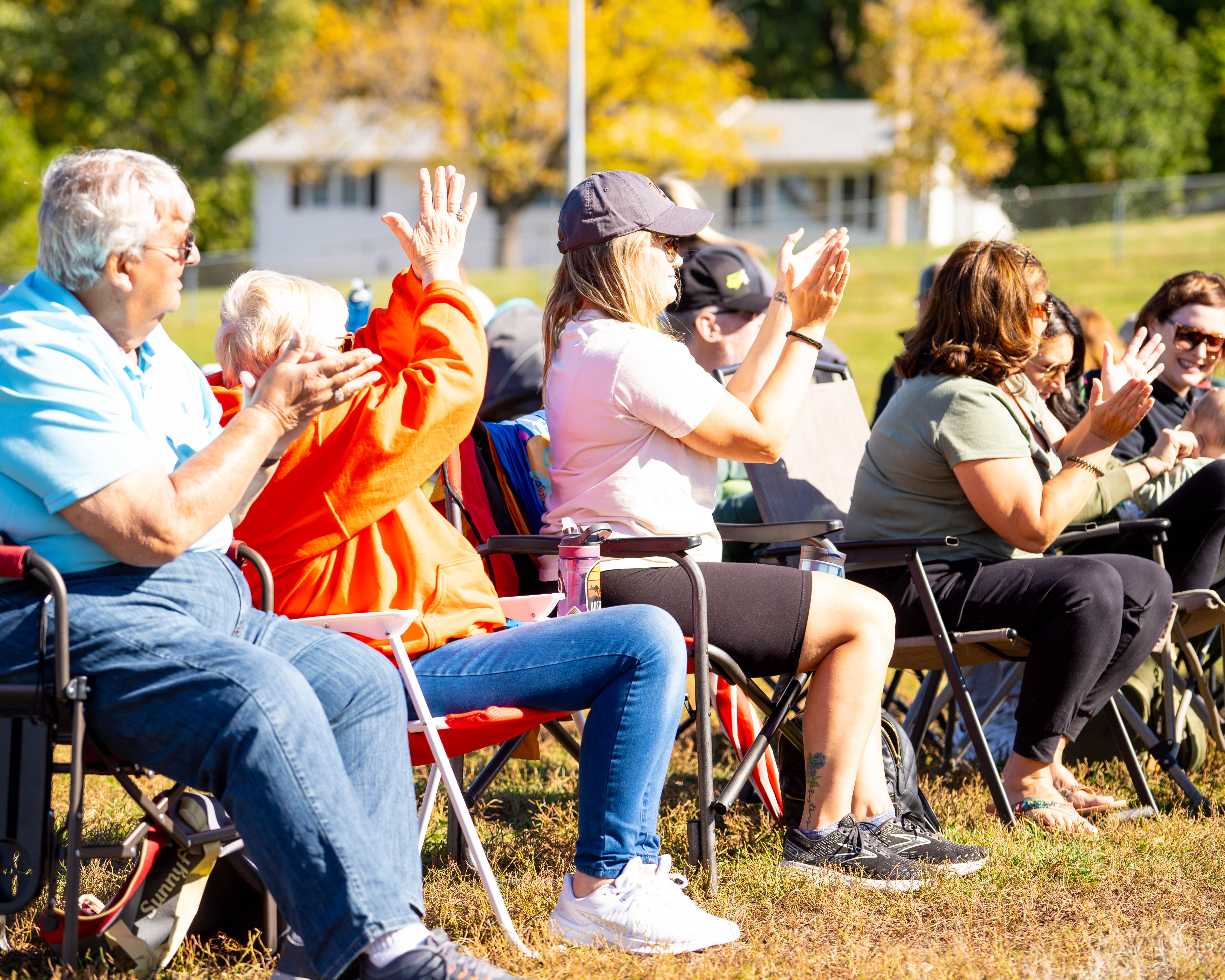 Parents cheering from the sideline on a sunny fall day